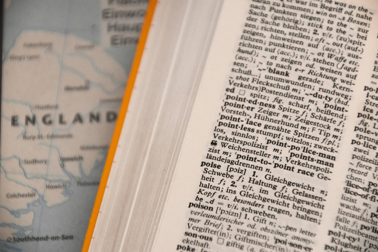 Open multilingual dictionary alongside a map, illustrating cross-language document translation